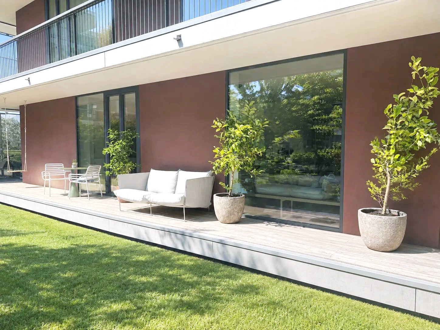 Holzterrasse entlang der Wohnung mit Sitzbereich