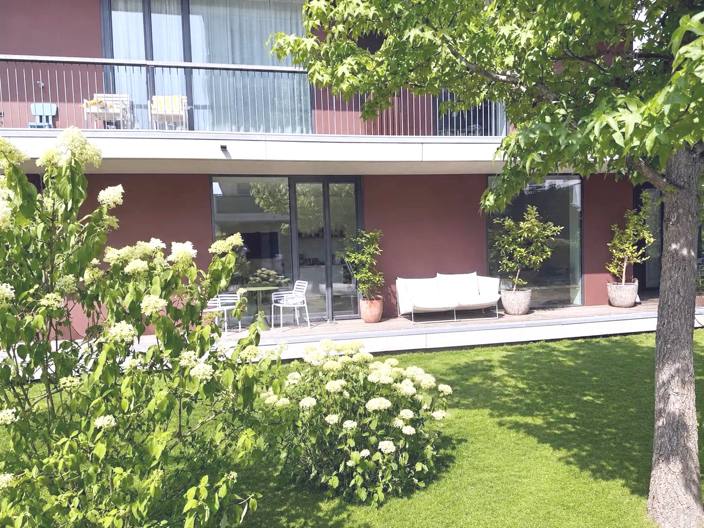 Terrasse mit Lounge, Zitruskübeln und blühenden Hortensien
