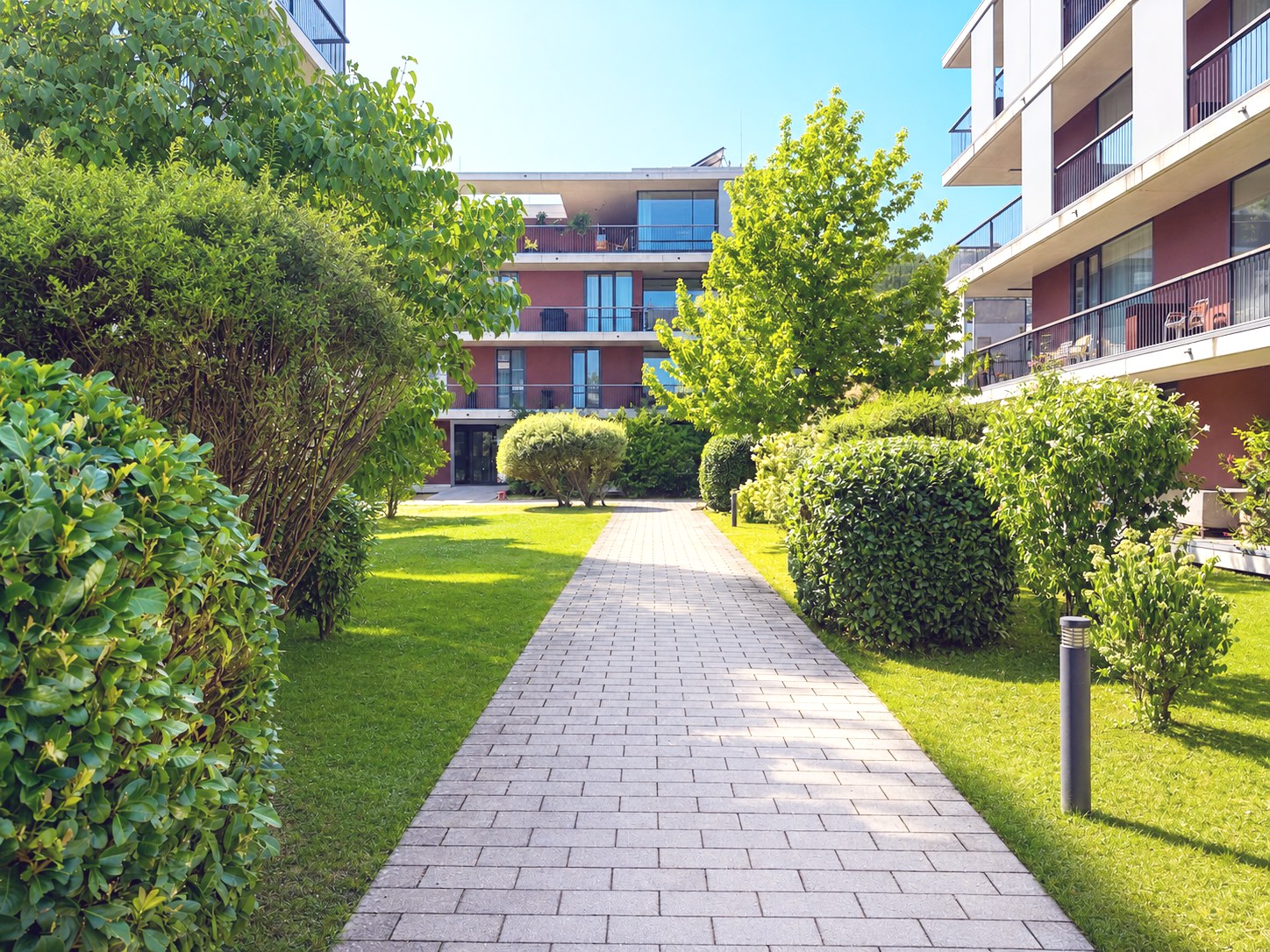 Gartenhof der Anlage mit Wegen, Rasen und Heckenpflanzung